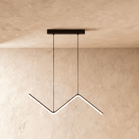 Black zigzag pendant lit against a warm plaster wall from a slim ceiling plate