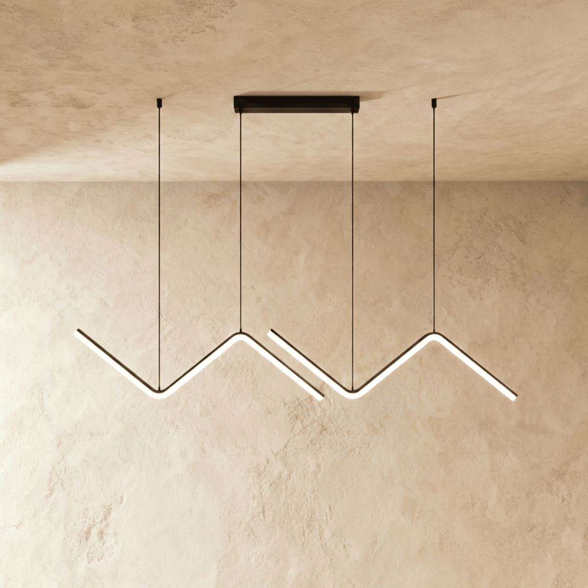 Three black zigzag pendant bars lit in a row against a plaster wall