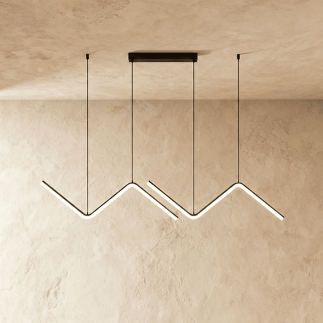 Three black zigzag pendant bars lit in a row against a plaster wall